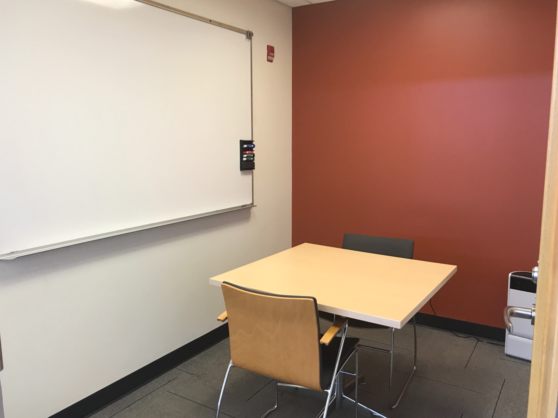 Image of study room with a whiteboard, two chairs and a desk.