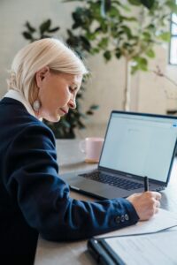 Person Writing and Typing at a Desk
